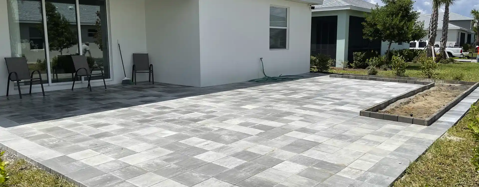Large gray paver patio installed behind a home